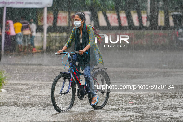 A woman riding a cycle during the rainfall in Dhaka, Bangladesh on July 31, 2021. 