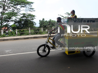 A man wearing a face mask seen riding an eco-friendly electric bicycle cargo for garbage non-organic in Bogor, West Java, Indonesia, on Augu...