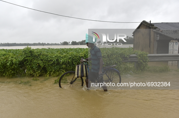 A villager with a bicycle wades through a flooded street in Udaynarayanpur, Howrah district of West Bengal, India, 04 August, 2021.  
