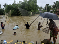 Villagers catch fish during a massive flood in Udaynarayanpur, Howrah district of West Bengal, India, 04 August, 2021.  (