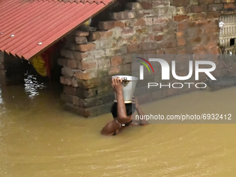 A man takes household items from his house which got submerg under the flooded water in Udaynarayanpur, Howrah district of West Bengal, Indi...