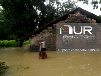A villager wades through a flooded water in Udaynarayanpur, Howrah district of West Bengal, India, 04 August, 2021.  (