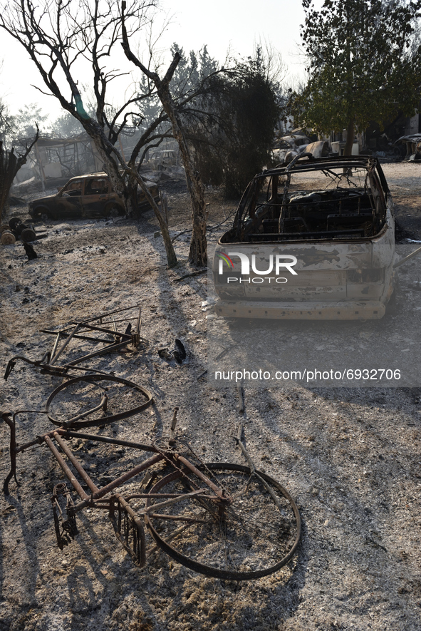 Bicycles and cars are destroyed by the wildfire in the northern suburb of Athens Varimpompi, on August 4, 2021. 