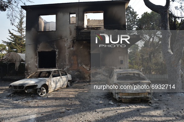 Two cars are destroyed in front of burned down equestrian club building by the wildfire in the northern suburb of Athens Varimpompi, on Augu...