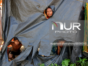 In this picture taken on August 05, 2021, Indian residents sit next to a makeshift tent along a road after moving to higher ground from a fl...