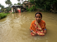 A flood victim wades his way through the flooded locality at Amta-2 in the Howrah district about 82 kms from Kolkata on August 7, 2021.  (