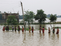 People wade through a waterlogged street in the flood hit city of Amta in the Howrah district about 82 kms from Kolkata on August 7, 2021. (
