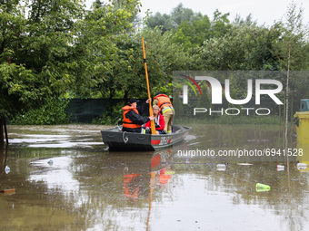 Firefighters are swimming on a boat after streets and households areas of Bierzanow district were flooded with heavy rain shower in Krakow,...