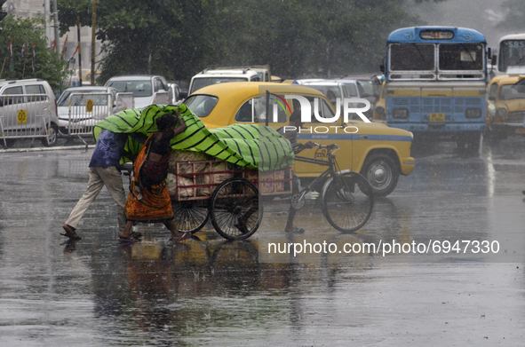 People cross a road during heavy rainfall in Kolkata, India, 10 August, 2021.  