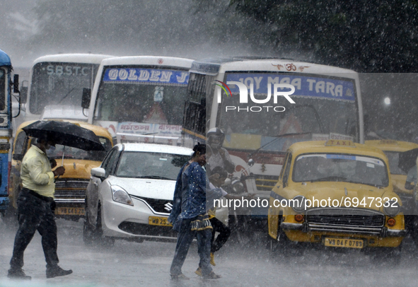 People cross a road during heavy rainfall in Kolkata, India, 10 August, 2021.  