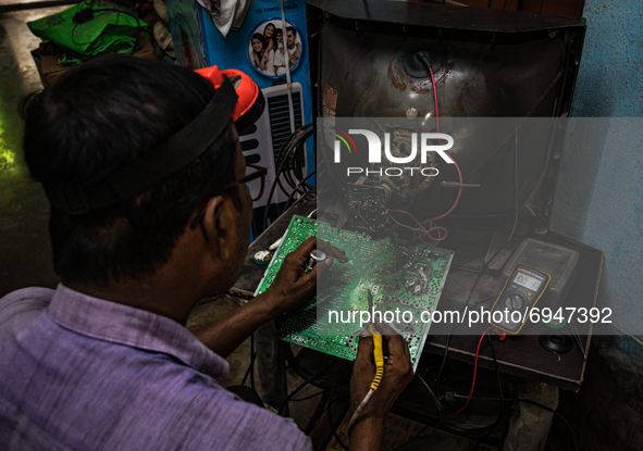 A television mechanic is repairing a printed circuit board (PCB) of the TV in Tehatta, West Bengal; India on 10 August 2021. According to th...