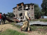 A man looking at the damaged building where according to police a militant was killed in an encounter in south Kashmir's Kulgam area, India...