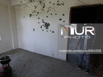 A boy looks at the wall of the damaged building where according to police a militant was killed in an encounter in south Kashmir's Kulgam ar...