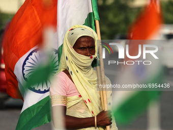 A woman sells Indian national flags along a road, ahead of India's 75th Independence day celebrations, in New Delhi, India on August 13, 202...