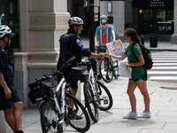 A demonstrator hands a police officer a flyer during a protest on August 13, 2021 in Washington, D.C., USA. The protestors demanded the bank...