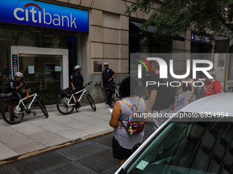 Police block a bank entrance as demonstrators with the organization Climate First! protest outside of several branches of major banks on Aug...