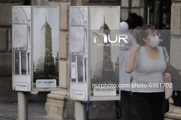 A woman walks between telephone booths in the Historic Centre of Mexico City after heavy rains and strong gusts of wind due to Hurricane Gra...