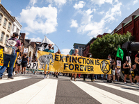 New Hampshire Extinction Rebellion members carry a banner in a march of hundreds of protesters against Enbridge's Line 3 oil pipeline, spons...