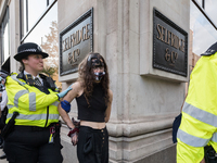 LONDON, UNITED KINGDOM - AUGUST 24, 2021: An environmental activist from Extinction Rebellion is arrested and led away by a police officer f...