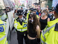 LONDON, UNITED KINGDOM - AUGUST 24, 2021: Environmental activists from Extinction Rebellion are arrested and led away by police officers fol...