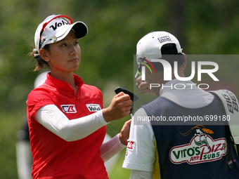 Chella Choi of Seoul, South Korea fist bumps in celebration with her father and caddy Ji Yeon Choi after making her putt on the 12th green i...