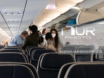 Passengers inside the cabin of an airplane are disembarking an Aegean Airlines Airbus A320neo after a domestic flight from Athens while they...
