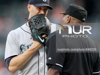 Seattle Mariners starting pitcher J.A. Happ talks to home plate umpire Las Diaz after the second inning of a baseball game against the Detro...