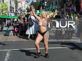 LONDON, UNITED KINGDOM - AUGUST 25, 2021: A topless environmental activists from Extinction Rebellion demonstrates on Oxford Street on the t...
