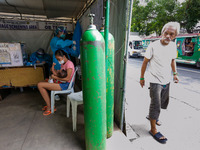 A man peeks at the triage area of a hospital placed along a main road in Manila City, Philippines on August 26, 2021. At least two more hosp...