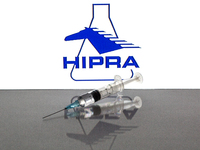In this photo illustration, a close up of a medical syringe in front of the Hipra, S.A. logo (