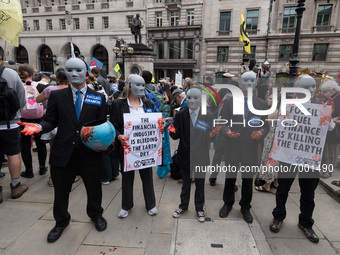 LONDON, UNITED KINGDOM - AUGUST 27, 2021: A group of environmental activists from Extinction Rebellion wearing masks and fake-blood stained...