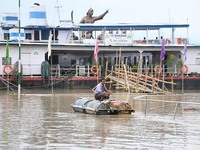 :A man  use a makeshift  raft in flood water caused by heavy rain and overflowing of river Brahmaputra river, following heavy monsoon rain a...