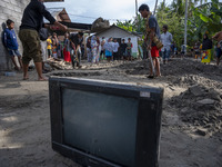 Residents dig in front of their houses to lift motorbikes that were buried in mud after being hit by a flash flood in Rogo Village, South Do...