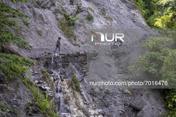 Motorists cross the Trans Palu-Kulawi Road which is buried by landslide material in Namo Village, Sigi Regency, Central Sulawesi Province, I...