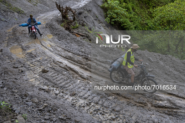 Riders ride oxygen cylinders across the Palu-Kulawi Trans Road which was buried by landslide material in Namo Village, Sigi Regency, Central...