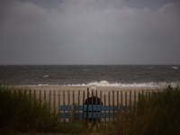 A woman watches waves crash on shore as remnants of Hurrican Ida hit Cape May Point, New Jersey, the southern-most tip of the state on Septe...