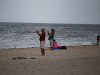 People photograph waves crashing on shore as remnants of Hurrican Ida hit Cape May Point, New Jersey, the southern-most tip of the state on...