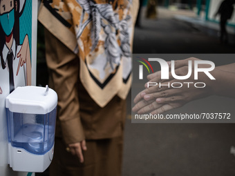 A student disinfects his hands before entering the classroom, in South Tangerang, Indonesia, on September 6, 2021. Indonesia government ease...