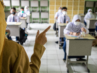 A teacher gives Biology lessons to students, in South Tangerang, Indonesia, on September 6, 2021. Indonesia government eased the Covid-19 re...