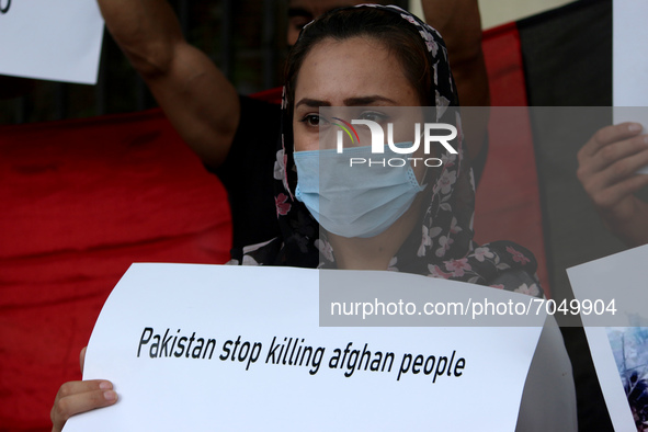 An Afghan national residing in India holds a placard during a demonstration against Pakistan's alleged support to the Taliban, in New Delhi,...