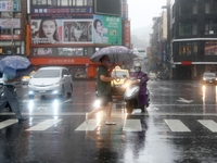 People with umbrellas walk in strong  rains and winds in Keelung, as Typhoon Chanthu bringing torrential rains and damaging winds makes land...