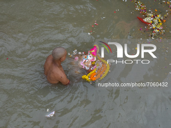 A devotee carries an idol of Ganesh for immersion at a Ganges riverside in Kolkata , India , on 12 September 2021 . (
