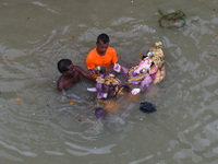 Devotees carries an idol of Ganesh for immersion at a Ganges riverside in Kolkata , India , on 12 September 2021 . (