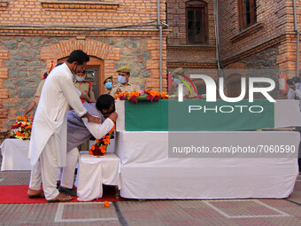 SRINAGAR, KASHMIR, INDIA-SEPTEMBER 12: A relative kissing the coffin containing the dead body of a police officer at District Police Lines i...