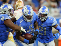 Detroit Lions outside linebacker Jamie Collins (8) is congratulated by teammates after carrying the ball for yardage during an NFL football...