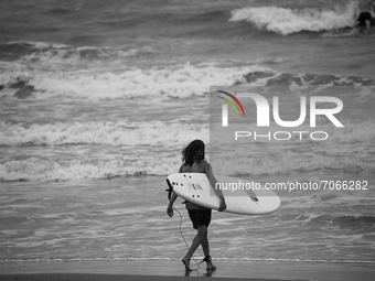 A man surfs on the beach on Galveston Island as Tropical Storm Nicholas approaches the coast. September 12th, 2021, Galveston, Texas.  (