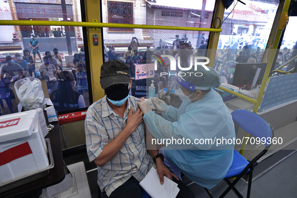 An elderly man receives a dose of AstraZeneca COVID-19 vaccine in a vehicle of the BKK Mobile Vaccination Unit on September 20, 2021 in Bang...
