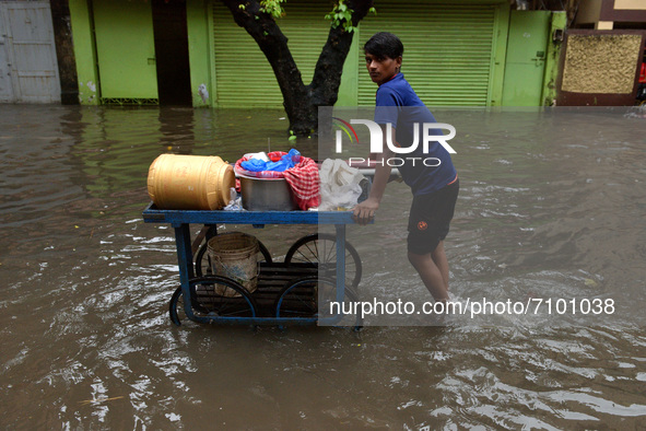 A street vendor is seen moving through a water logged street in Kolkata as many parts of West Bengal including the capital city of Kolkata,...
