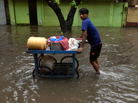 A street vendor is seen moving through a water logged street in Kolkata as many parts of West Bengal including the capital city of Kolkata,...