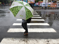 A man is seen crossing the road during downpour in Kolkata as many parts of West Bengal including the capital city of Kolkata, witnessed ver...